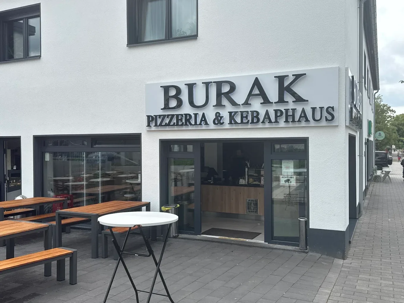 Außenansicht von Pizzeria & Kebaphaus Burak in der Thingstraße mit Sitzplätzen draußen